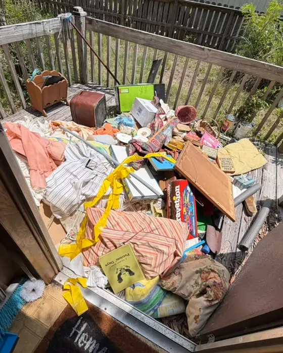 Porch with a heap of clothes, boxes and trash