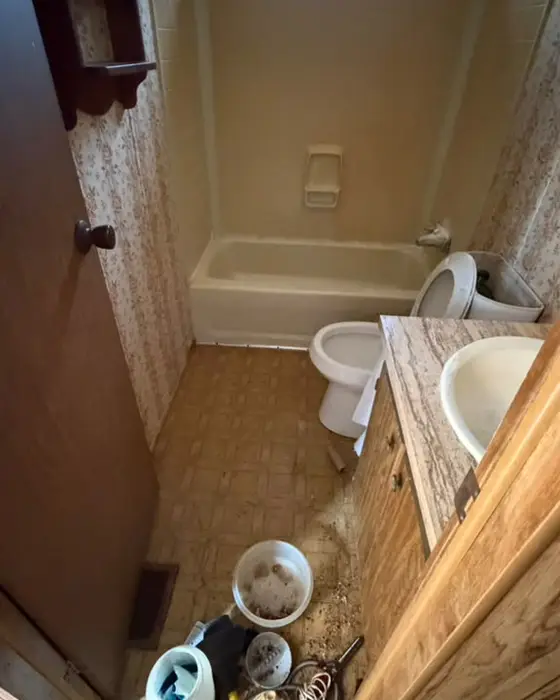 Dirty bathroom with things scattered on the floor