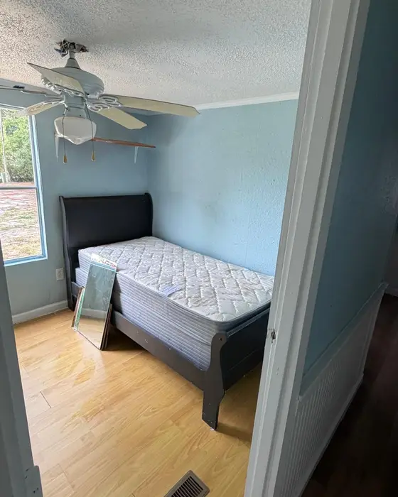 After: the same room tidied up with the bed set up and a clean floor
